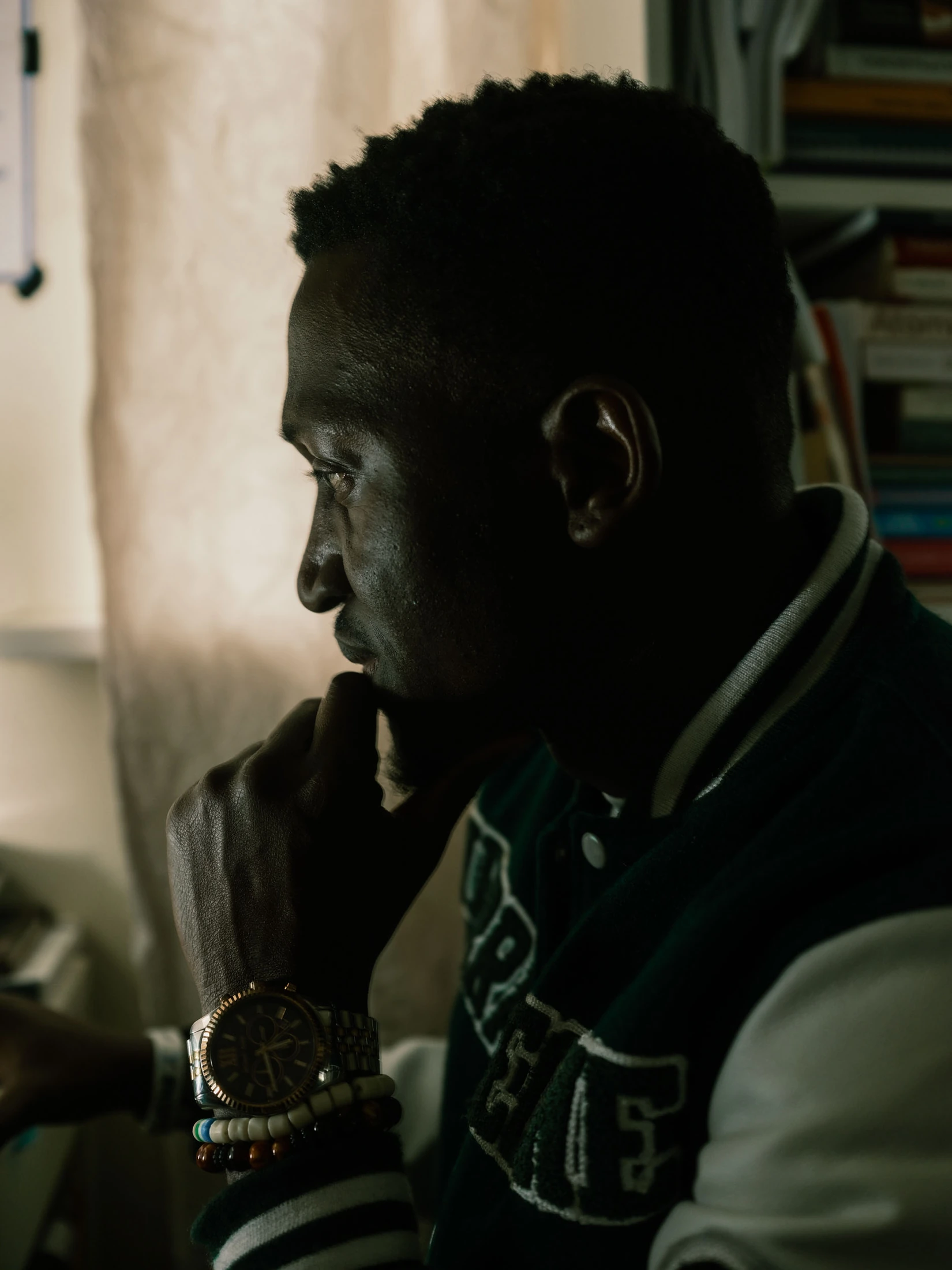 Abdulai seated in profile by a window