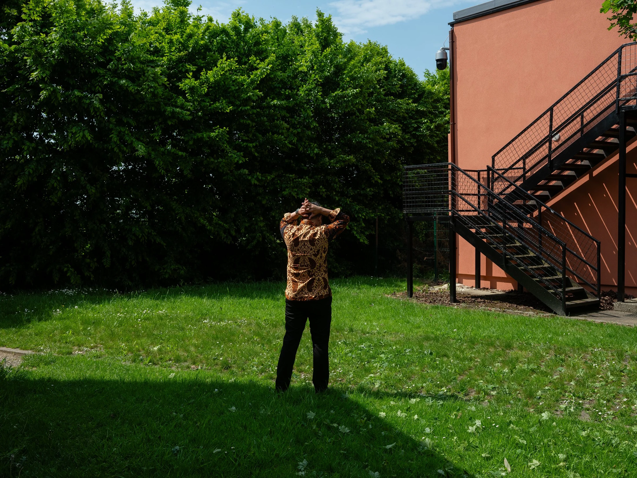 Gabe standing in a sunlit garden
