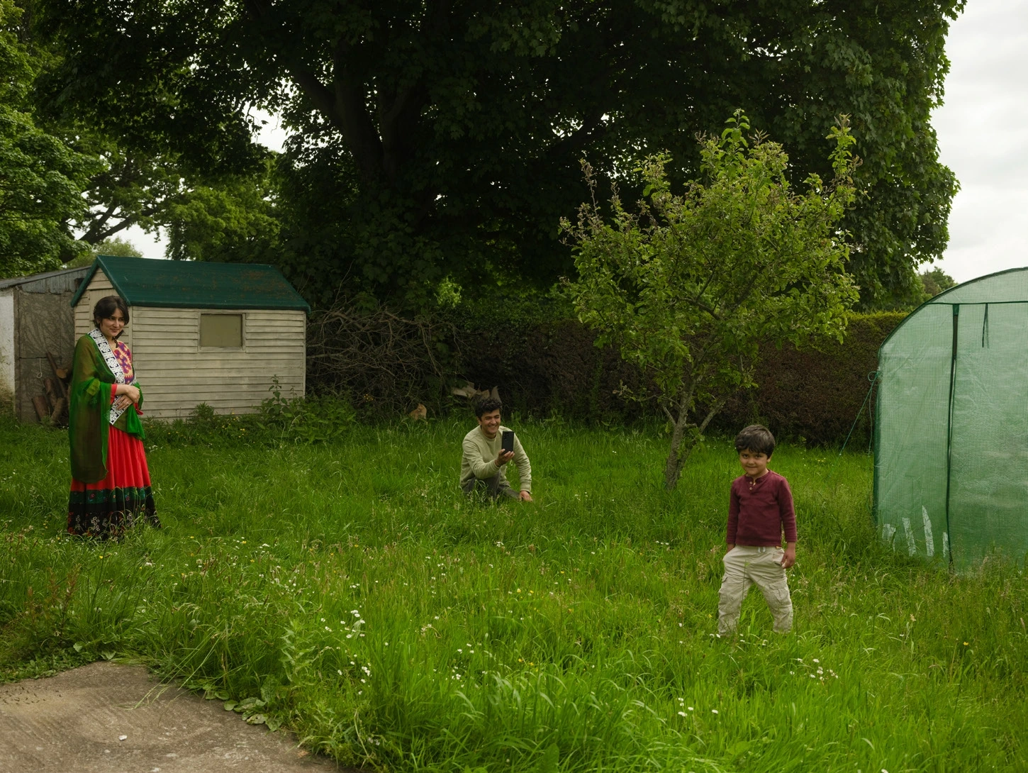 Family members standing among long grass in a garden