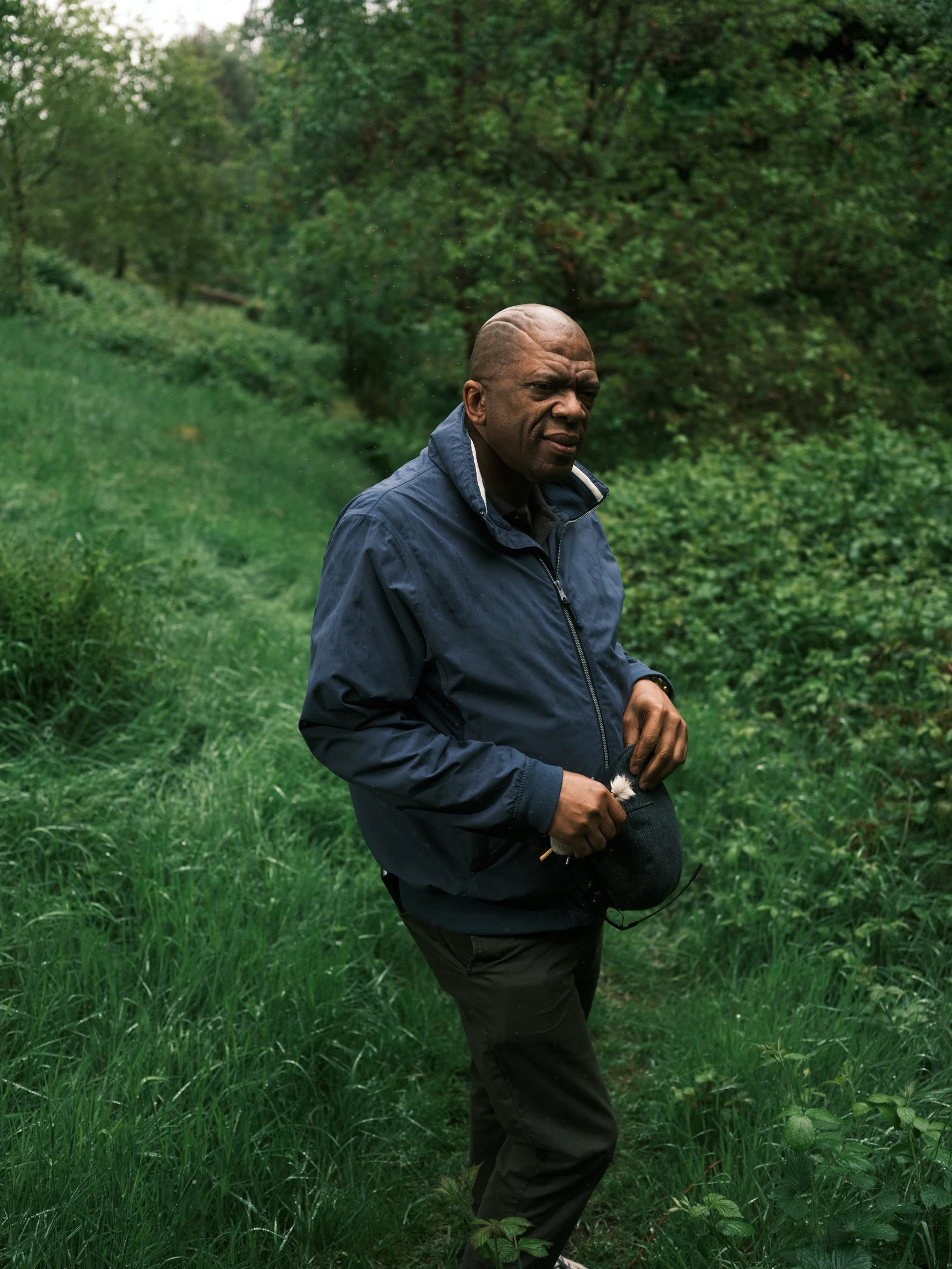 Lucky Khambule standing in a wooded glen, wearing a dark blue jacket