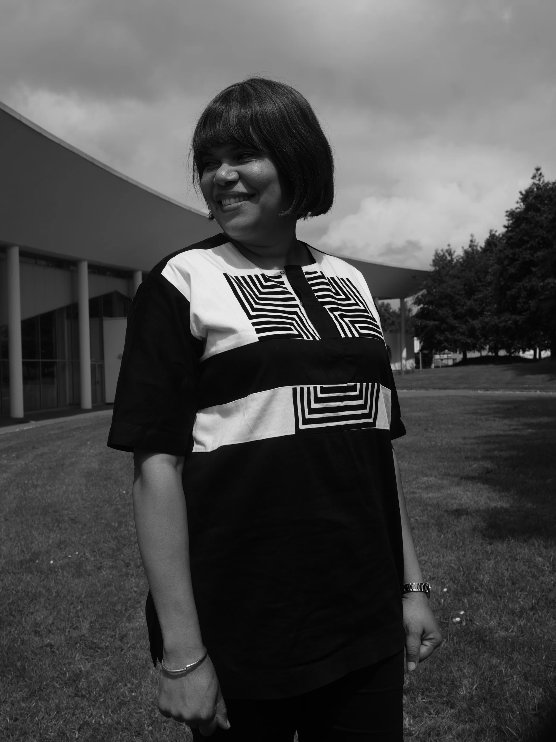 Rita smiling outdoors in a patterned black and white dress
