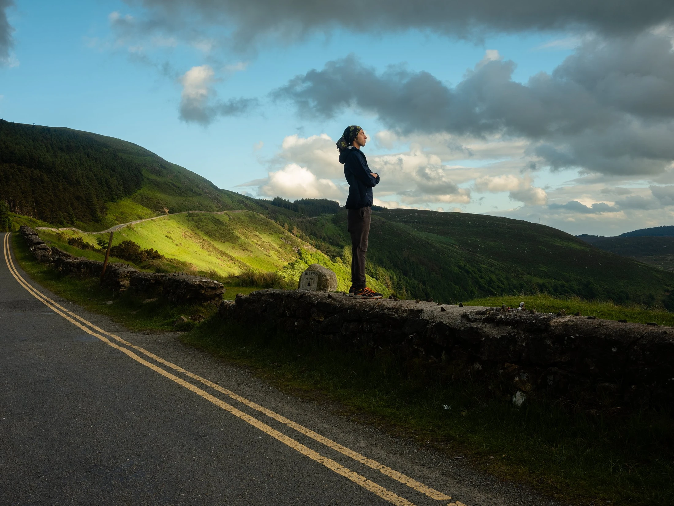Siavash on a stone wall in a mountain landscape
