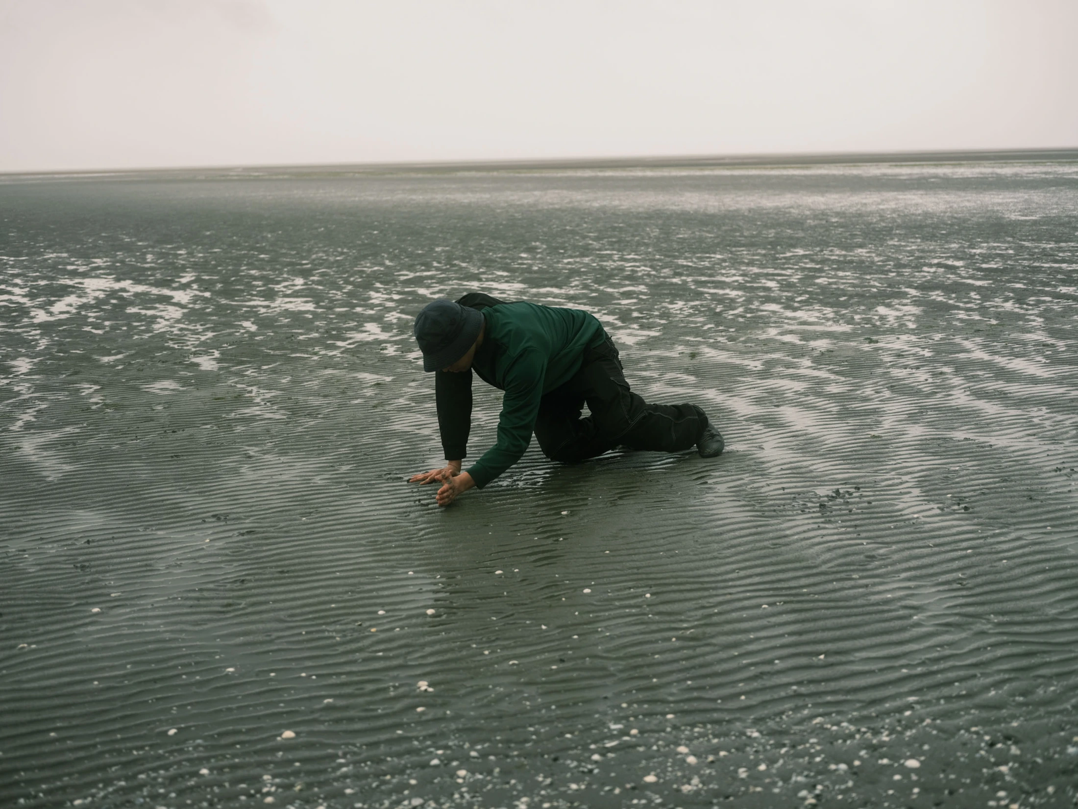 Salah kneeling beside shallow water at the shore