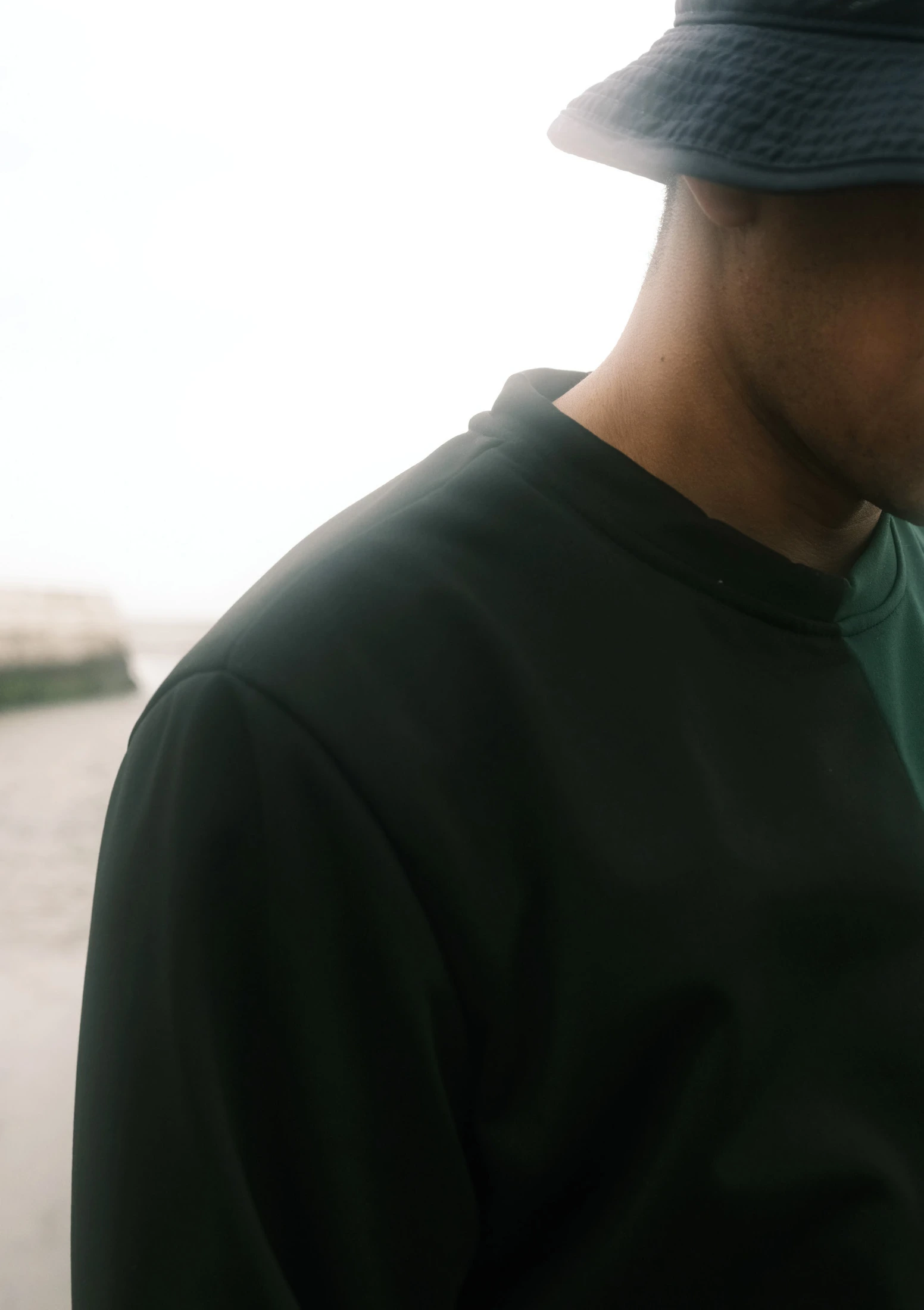 Close view of a black T-shirt and bucket hat beside the sea
